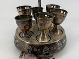 a silver plate with cups and spoons on it