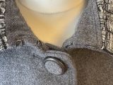 the jacket is made of wool and has buttons on the collar