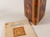 un vieux livre posé sur une table blanche à côté d'un livre