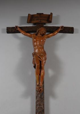 statue de Jésus sur une croix, sur laquelle est fixée une plaque en bois