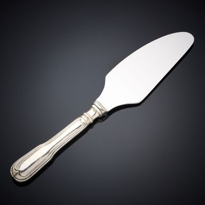 a silver cake knife with a handle on a black surface