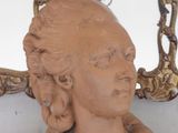 a statue of a woman that is sitting in front of a mirror