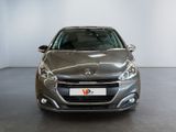 the front of a silver car in a showroom with a white wall
