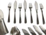 many different types of silverware on a white surface