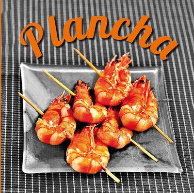 une assiette de crevettes enfilées sur des brochettes, posée sur une table