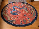 un tapis posé à même le sol, orné d'un motif représentant un dragon