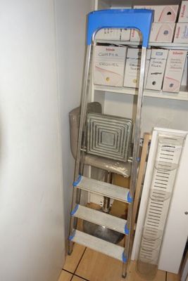une image représentant une échelle dans une pièce, sur laquelle sont posées des cartons
