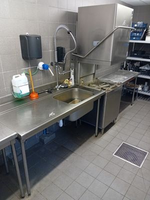une grande cuisine en inox équipée d'un évier et d'un réfrigérateur