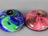 two colorful vases sitting next to each other on a table