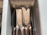 many forks and spoons in a box on the table