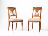 deux chaises en bois avec des assises rembourrées et un coussin d'assise à motifs