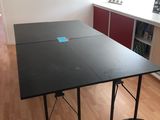 une table noire sur laquelle est collé un autocollant bleu, au milieu d'une pièce