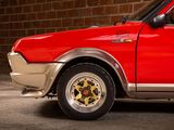 a red car that is parked in front of a brick wall
