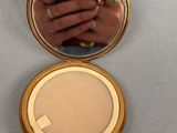 a close up of a person ' s hand in a compact mirror