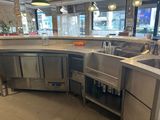 une grande cuisine avec des plans de travail en inox et un évier en inox