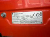 a close up of a red car with a metal plate