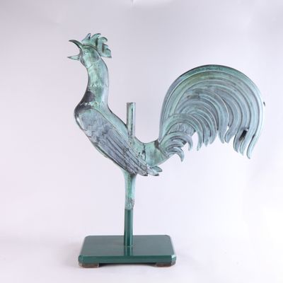 statue d'un coq sur un socle vert, sur fond blanc