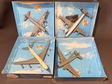quatre avions miniatures se trouvent dans une boîte posée sur une surface marron
