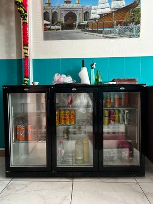 two refrigerators that are sitting in a room