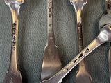 four spoons and two forks on the table