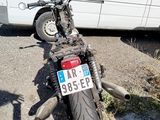 a motorcycle parked next to a van on the side of the road