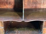 a wooden shelf that has two drawers on top of it