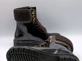 black boots with brown fur linings and a rubber sole on a white surface