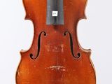 un vieux violon avec un archet accroché à son dos