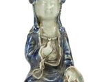 une petite statue représentant un Bouddha assis sur une surface blanche