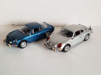 two toy cars sitting next to each other on a white surface