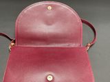 a red leather purse with a gold clasp on the front