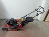 a red lawn mower that is sitting on the floor
