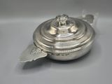an antique silver teapot with a lid on a white surface