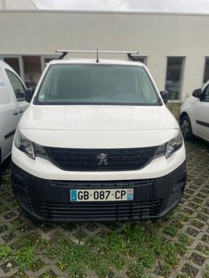 une camionnette blanche garée dans un parking à côté d'autres voitures