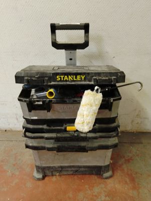 une boîte à outils noire sur laquelle est posée une éponge