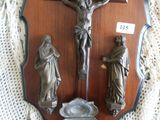 une plaque en bois sur laquelle sont représentés un crucifix et trois figurines