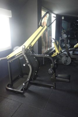 une salle de sport avec un banc, des poids et d'autres équipements