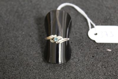 une bague en argent sertie d'une pierre bleue, à côté d'une étiquette de prix