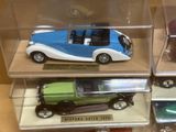 trois petites voitures dans une vitrine posée sur une table