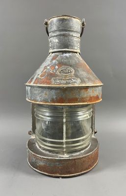 une vieille lampe en métal rouillée, surmontée d'un dôme en verre