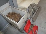 a metal container filled with rocks next to a red bucket