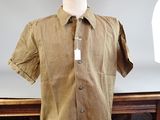 a mannequin in front of a brown shirt on a table