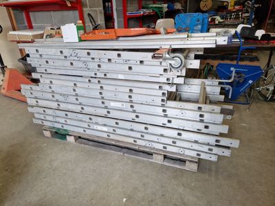 a pile of metal parts on a pallet in a garage