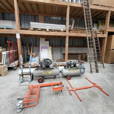 two air compressors sitting in the middle of a building