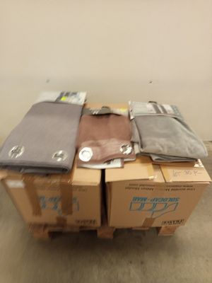 Des cartons de vêtements sont empilés les uns sur les autres dans une pièce