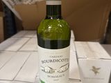 une bouteille de vin posée sur une table, avec des cartons en arrière-plan