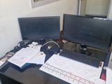 a desk with two computer monitors and a keyboard on it