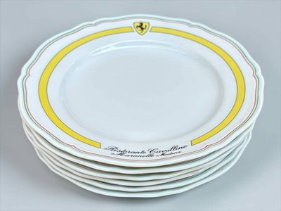 une pile d'assiettes ornées d'un emblème Ferrari