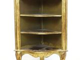 an image of a gold painted bookcase with a black cat on top of it