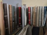 de nombreux rouleaux de tissu sur une étagère dans une pièce